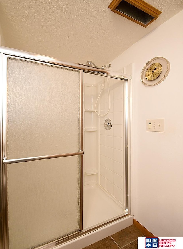 bathroom with tile patterned flooring and an enclosed shower