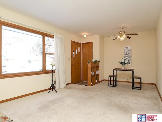 entryway featuring light colored carpet and ceiling fan