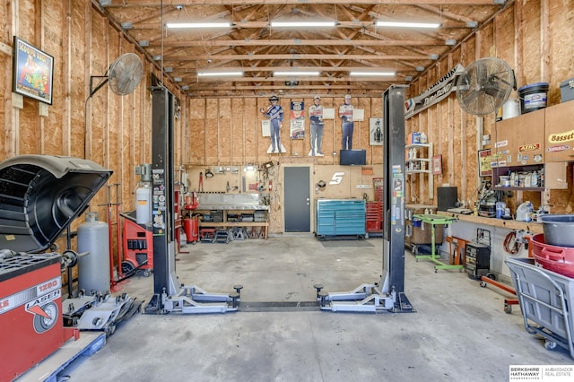 garage featuring a workshop area and wood walls