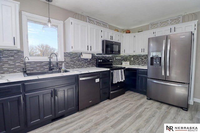 kitchen with white cabinets, pendant lighting, sink, and black appliances