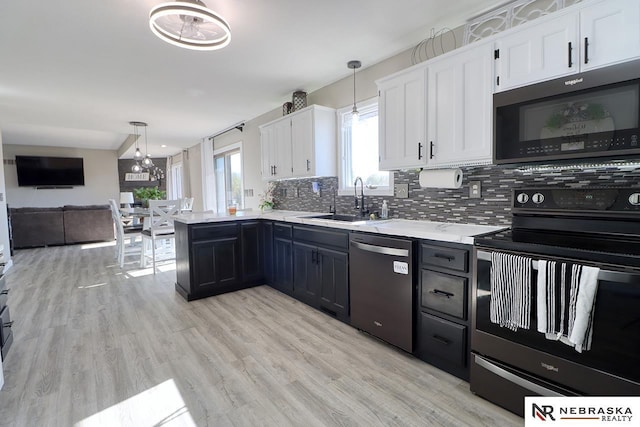 kitchen featuring white cabinetry, stainless steel appliances, and decorative light fixtures