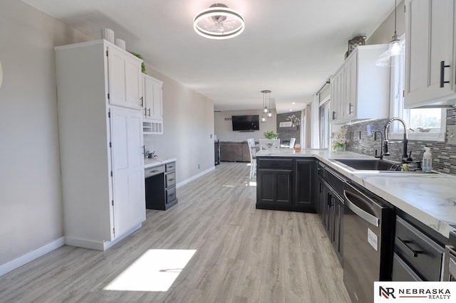 kitchen featuring sink, hanging light fixtures, stainless steel dishwasher, decorative backsplash, and white cabinetry