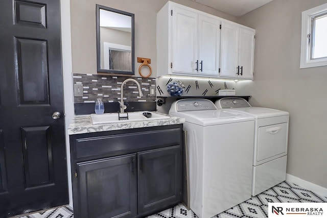 laundry room featuring cabinets, separate washer and dryer, and sink