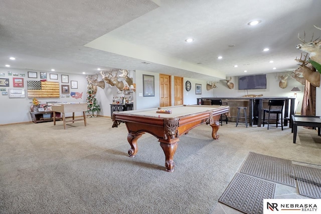 rec room with bar, light carpet, a textured ceiling, and billiards