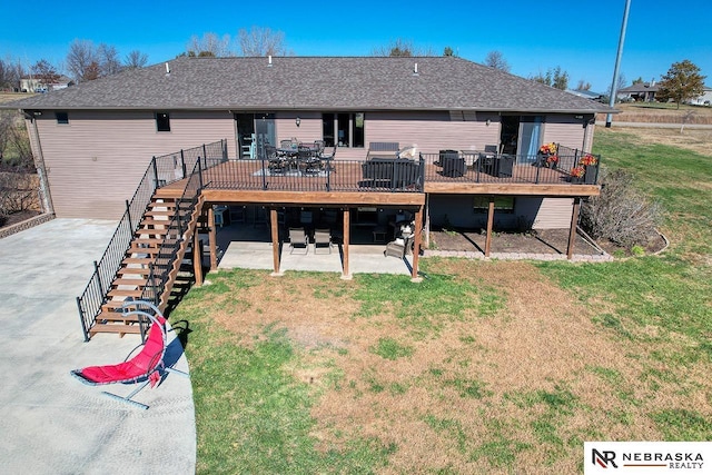 back of property with a lawn, a wooden deck, and a patio