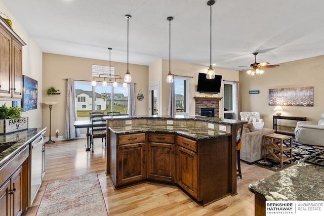 kitchen featuring dishwasher, a kitchen island, hanging light fixtures, and ceiling fan