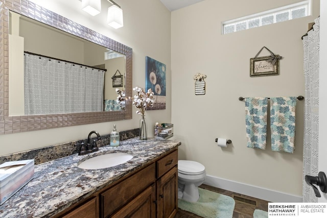 bathroom with hardwood / wood-style floors, vanity, and toilet