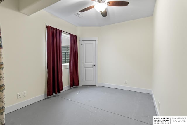 spare room with ceiling fan and concrete floors