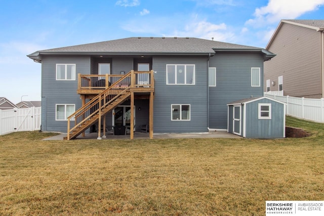 back of property featuring a yard, a patio, a deck, and a shed