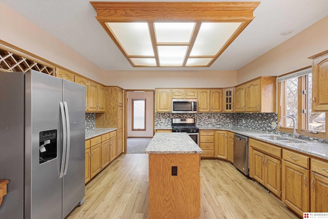 kitchen featuring sink, a kitchen island, stainless steel appliances, and light hardwood / wood-style floors