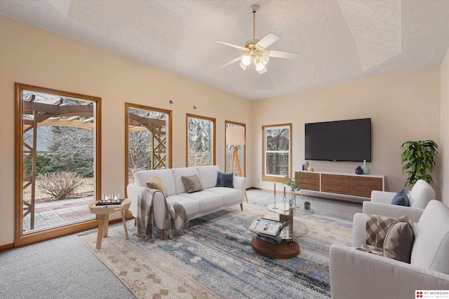 living room featuring a wealth of natural light, ceiling fan, and a textured ceiling