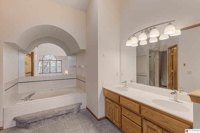 bathroom with vanity and tiled bath