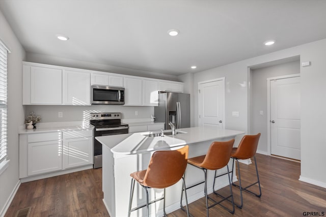 kitchen featuring white cabinetry, a center island with sink, stainless steel appliances, and sink