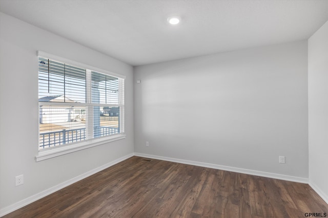 unfurnished room with dark wood-type flooring