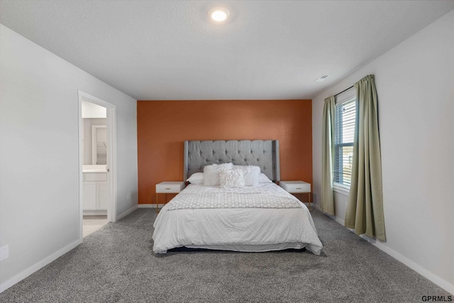 bedroom featuring connected bathroom and carpet floors