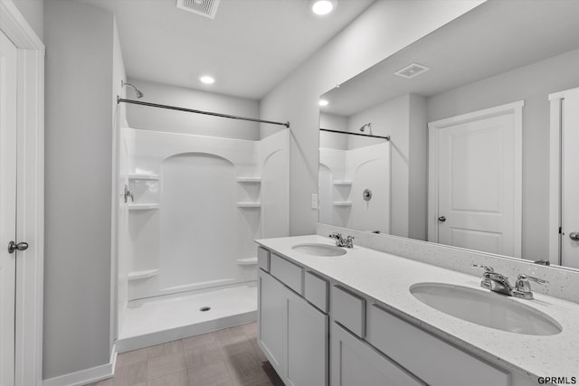 bathroom featuring a shower and vanity