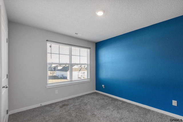 spare room with carpet and a textured ceiling