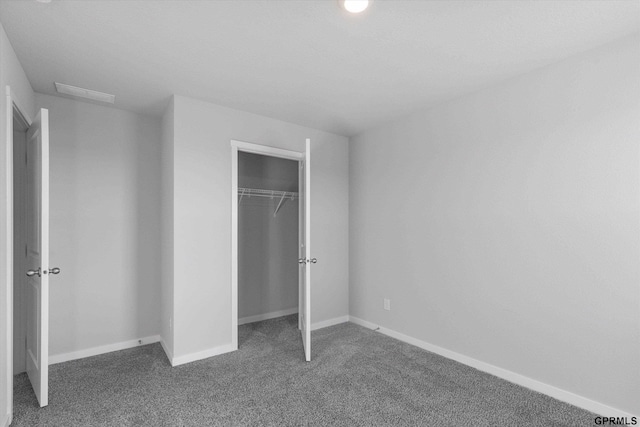 unfurnished bedroom featuring a closet and dark colored carpet