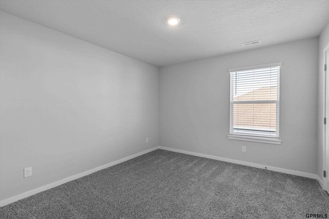 carpeted empty room with a textured ceiling