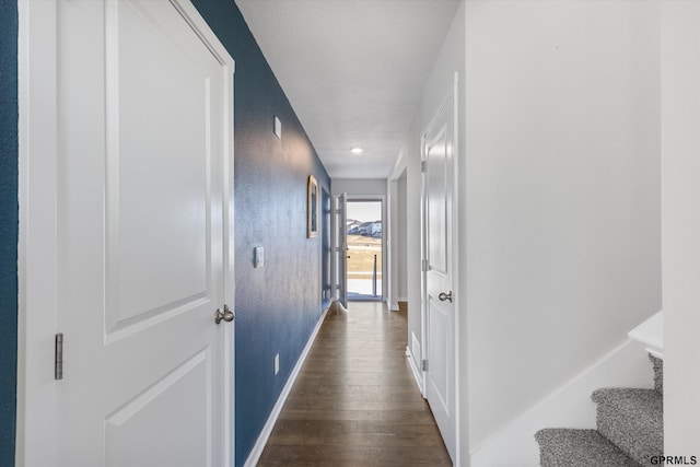 corridor with dark hardwood / wood-style floors and a textured ceiling