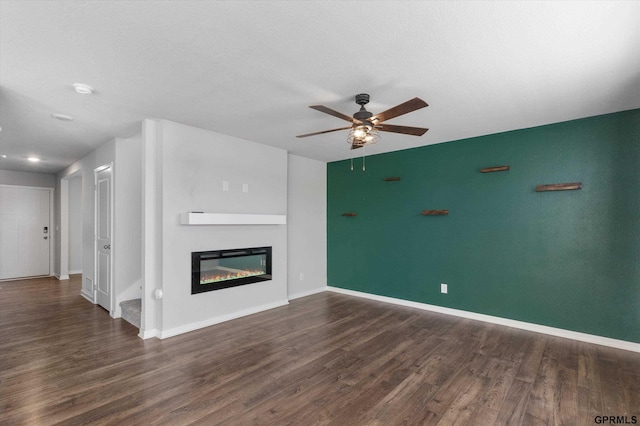 unfurnished living room featuring a textured ceiling, dark hardwood / wood-style floors, and ceiling fan