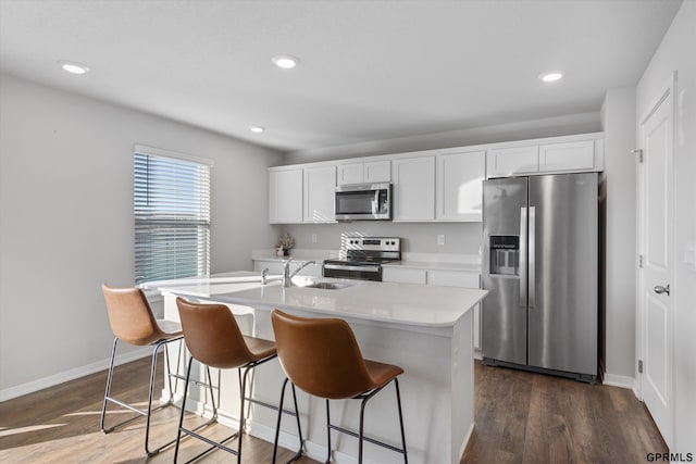 kitchen with white cabinetry, a center island with sink, and appliances with stainless steel finishes