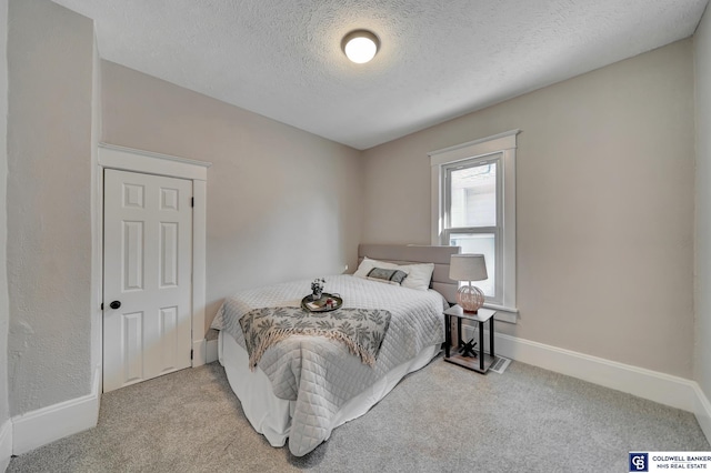 carpeted bedroom featuring a textured ceiling