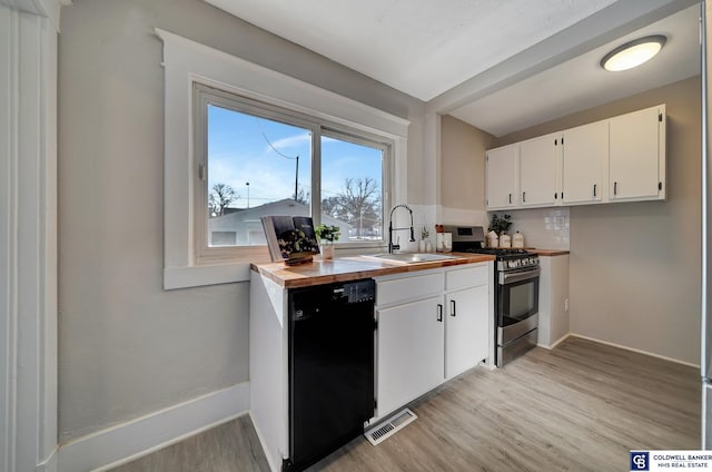 kitchen with sink, black dishwasher, stainless steel range with gas cooktop, wooden counters, and white cabinets