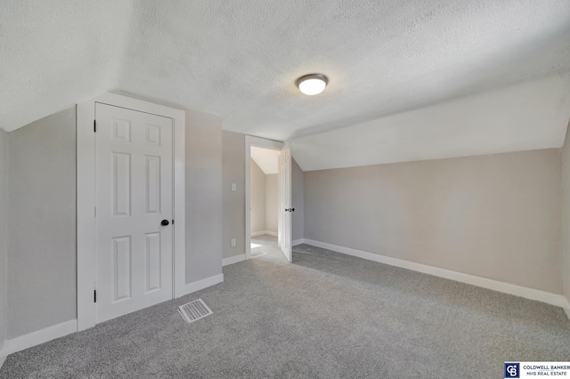 bonus room with a textured ceiling, carpet, and vaulted ceiling