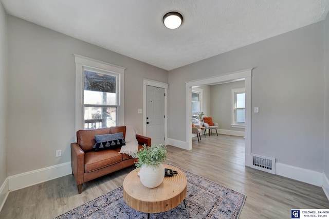 sitting room featuring a textured ceiling and light hardwood / wood-style floors