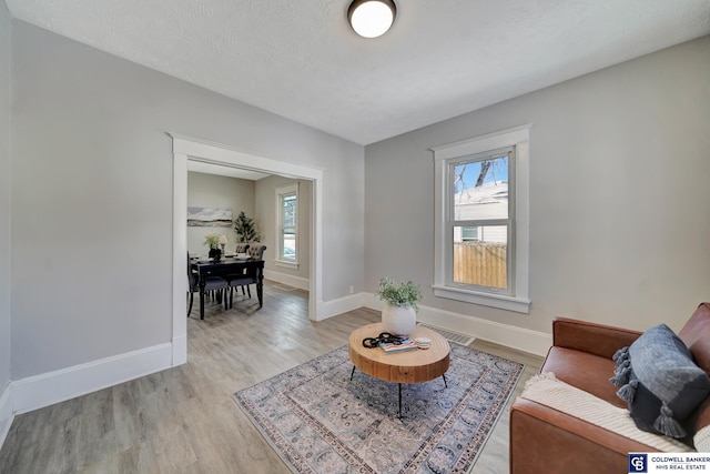 living room featuring a textured ceiling and light wood-type flooring