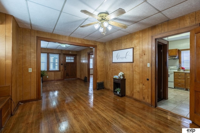 entrance foyer with a paneled ceiling, wooden walls, and wood-type flooring