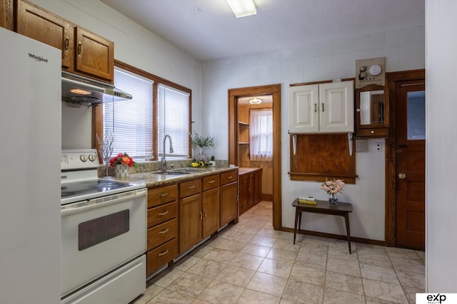 kitchen featuring a wealth of natural light, white appliances, sink, and range hood