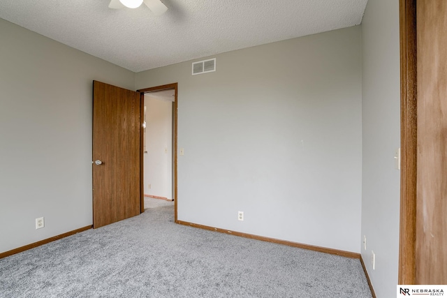 spare room featuring a textured ceiling, carpet floors, and ceiling fan