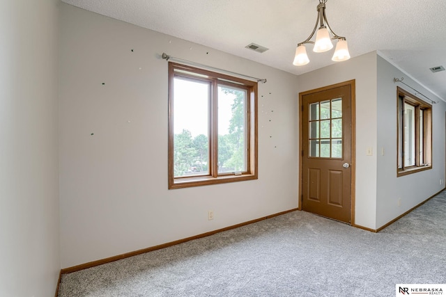 doorway with carpet, a textured ceiling, and a chandelier