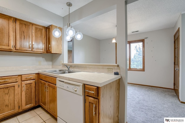 kitchen with sink, pendant lighting, kitchen peninsula, and dishwasher