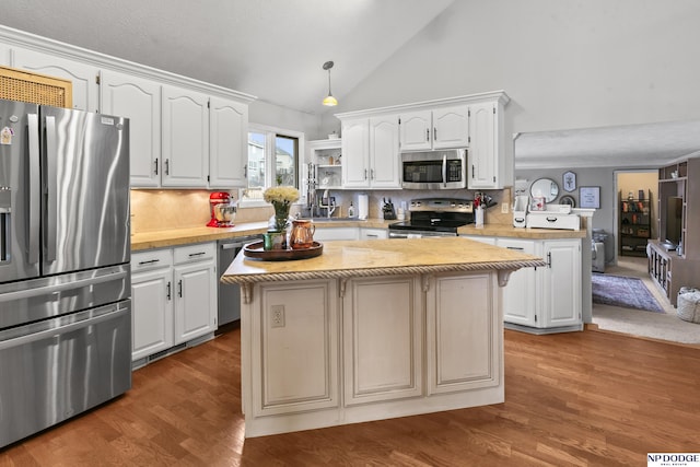 kitchen with tasteful backsplash, kitchen peninsula, a kitchen island, and stainless steel appliances