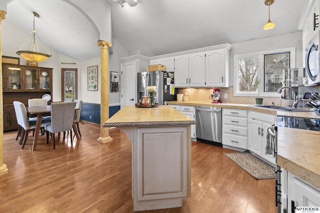 kitchen with white cabinetry, a center island, decorative light fixtures, and appliances with stainless steel finishes