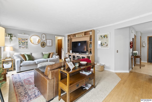 living room with crown molding, built in features, and light wood-type flooring