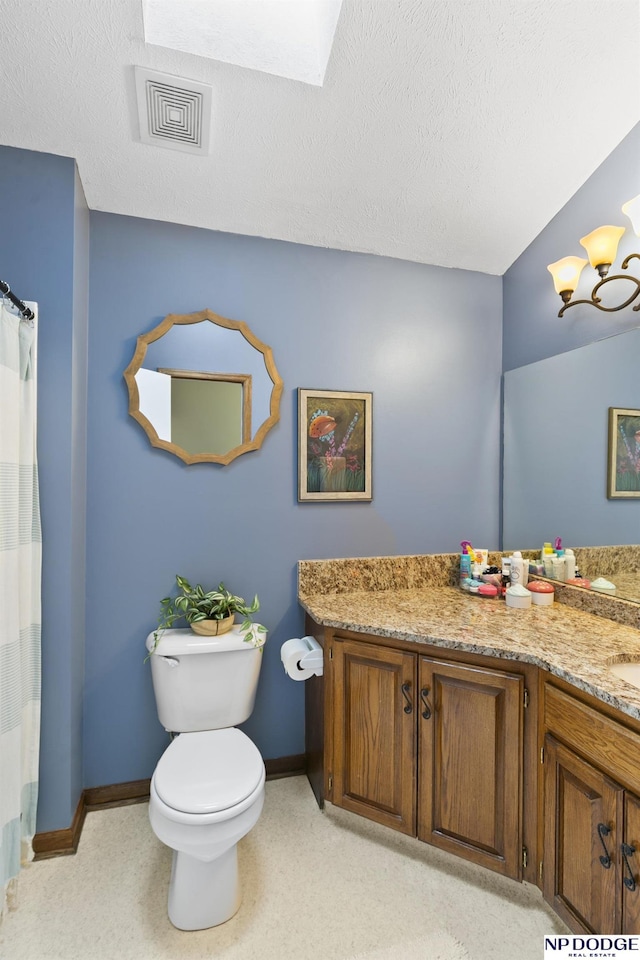 bathroom featuring vanity, a textured ceiling, and toilet