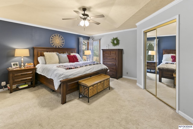 bedroom with light carpet, ornamental molding, a tray ceiling, ceiling fan, and a closet