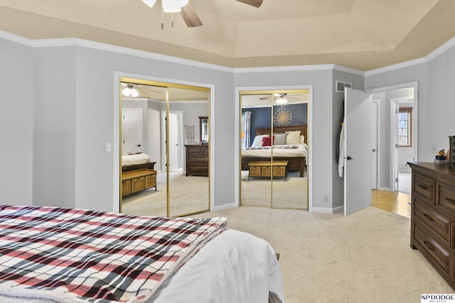 bedroom with a tray ceiling, ceiling fan, crown molding, and light carpet