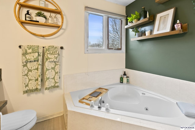 bathroom featuring toilet and tiled tub