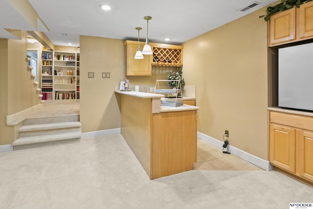 bar with light brown cabinets, light tile patterned floors, decorative light fixtures, and built in features