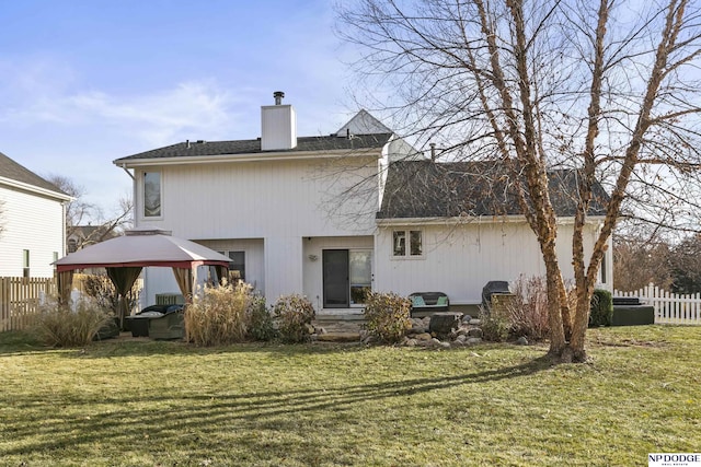 back of house featuring a gazebo and a yard