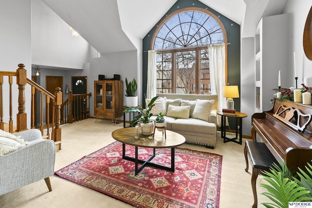 interior space with light colored carpet and high vaulted ceiling