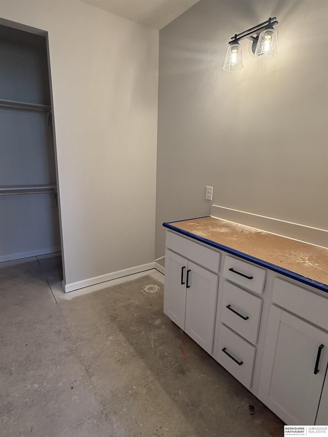 bathroom featuring baseboards and concrete floors
