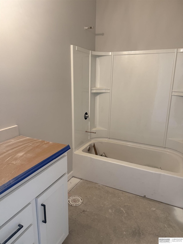 bathroom with unfinished concrete floors, vanity, and bathing tub / shower combination