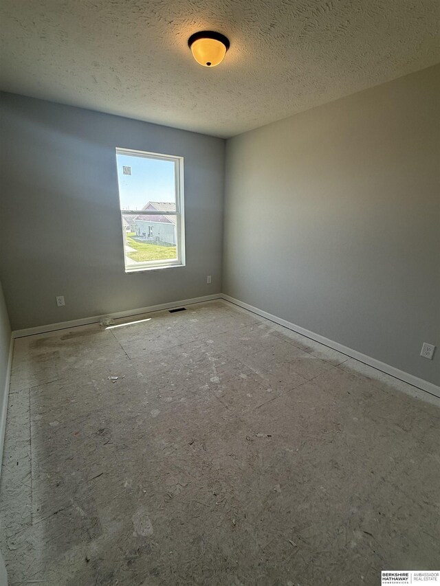 2175 N Aaron Way, Fremont, NE 68025 - unfurnished room with baseboards and a textured ceiling