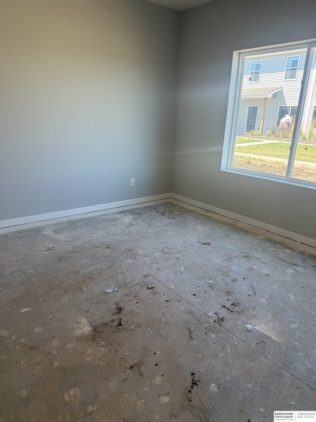 unfurnished room with baseboards